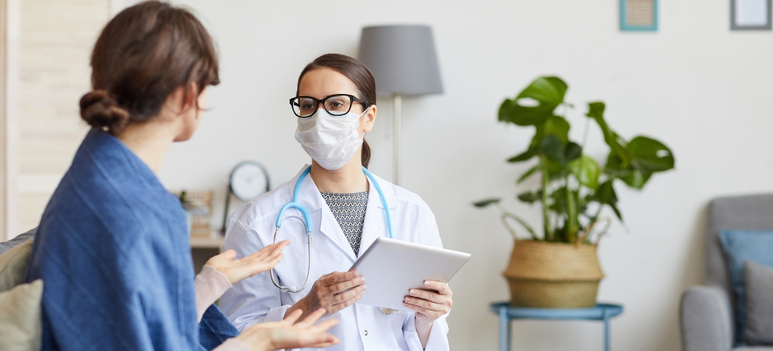 Evde doktor hizmeti için telefondan randevu alan bir kişinin ekranda görüşme yapması.