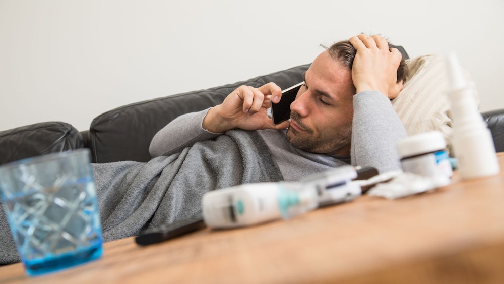 Evde doktorun hastayı dinleyip muayene ettiği, yanında stetoskop ve ölçüm cihazlarının bulunduğu bir sahne.