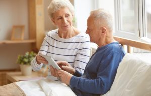 Evde sağlık ekibinin hastanın vital bulgularını ölçüp kayıt tuttuğu, yanında tıbbi çanta bulunan bir uygulama sahnesi.